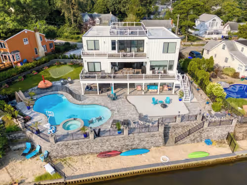 Beautiful waterfront 7 BR house w pool patio, outdoor bar, dock, putting green!